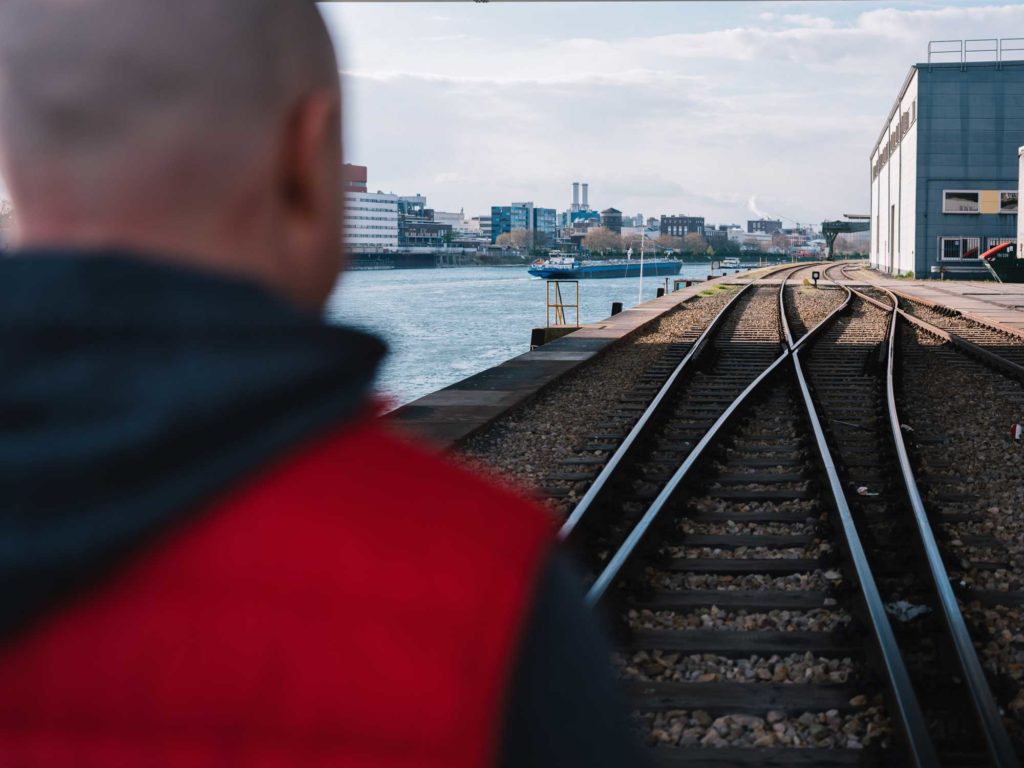Urs Hüchting von hinten auf Bahngleisen